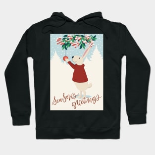 Cute rabbit in red sweater hanging up Christmas decorations in a snowy winter landscape Hoodie